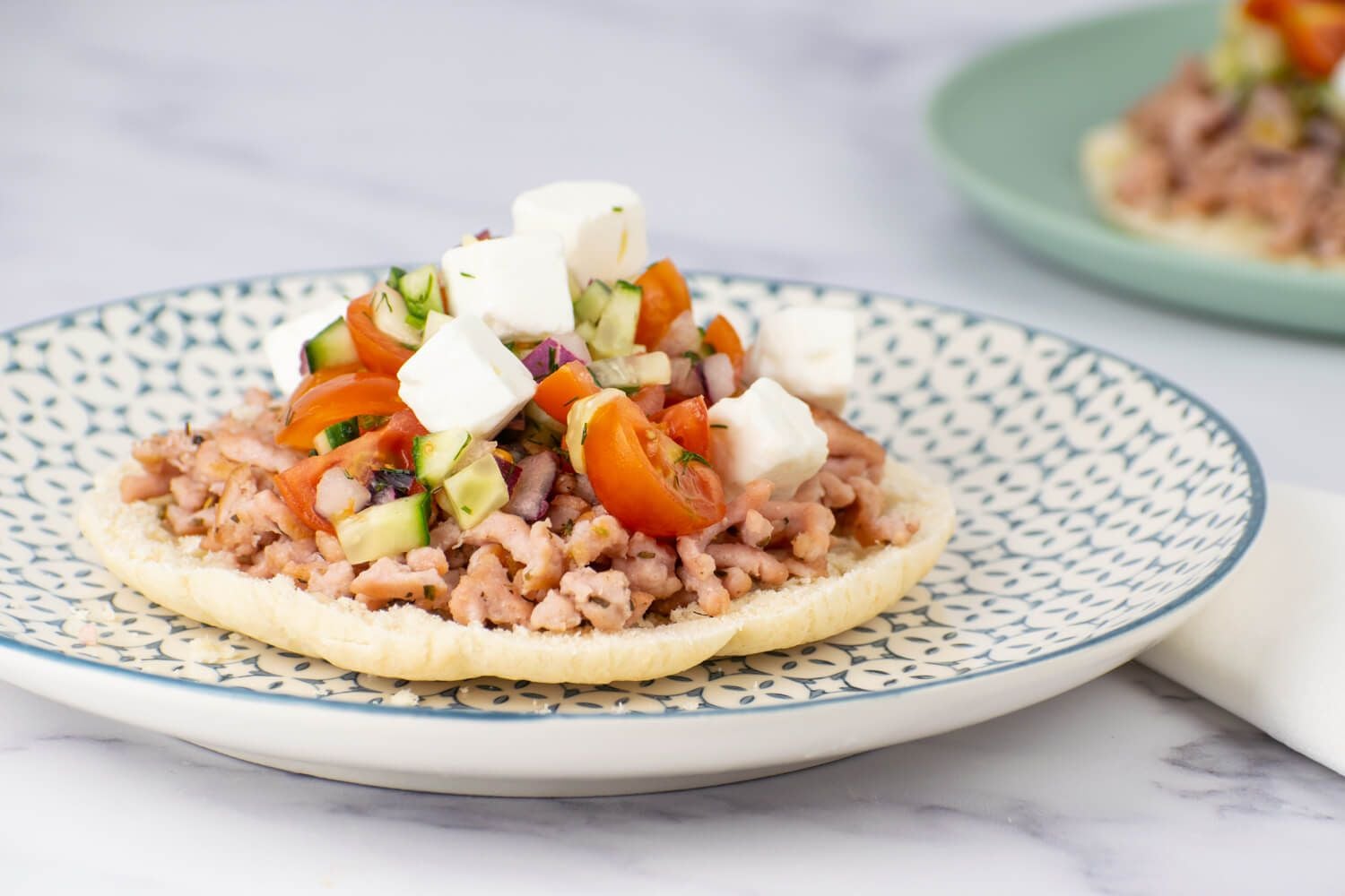 Greek Tostadas with Turkey Greek turkey tostadas with tomatoes, cucumbers, and feta cheese on toasted pita bread.