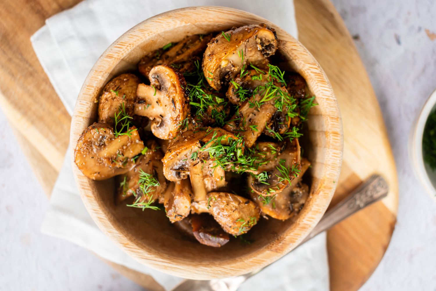 Roasted Mushrooms Roasted mushrooms with garlic, olive oil, and balsamic vinegar in a wooden bowl with fresh herbs.