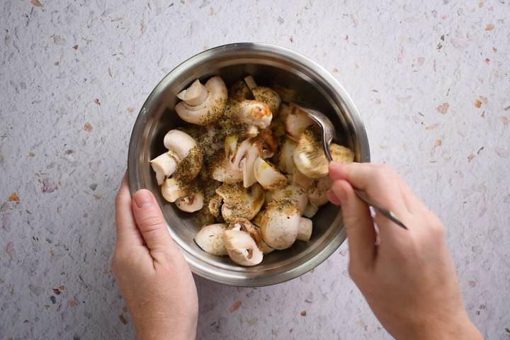 Roasted Mushrooms Halved mushrooms in a bowl with olive oil, balsamic vinegar, soy sauce, garlic, thyme, salt, and pepper.