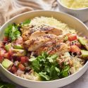 Chicken Taco Bowl Chicken taco bowls with sliced grilled chicken, pico de gallo, avocado, cilantro, and rice.