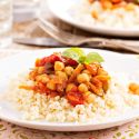 Slow Cooker Mediterranean Chickpeas Mediterranean chickpeas in a bowl with tomatoes, fresh herbs, and garlic.