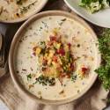 Slow Cooker Roasted Corn Chowder A bowl of creamy slow cooker roasted corn chowder topped with roasted vegetables, fresh thyme, and black pepper.