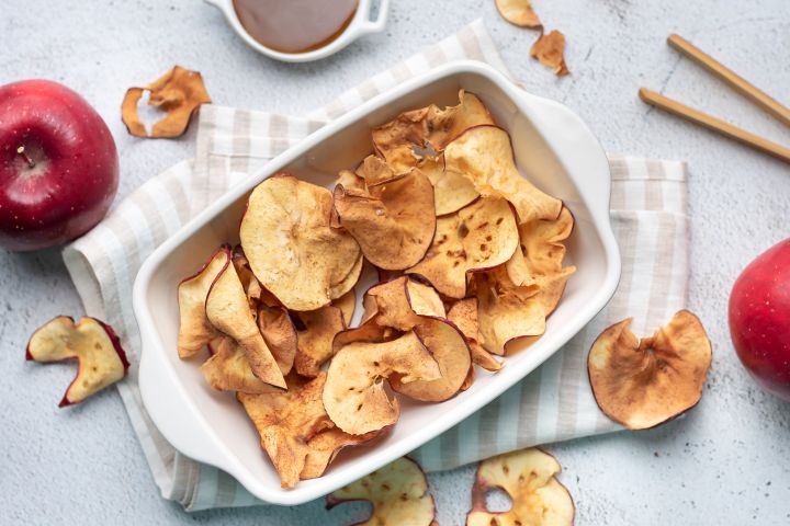 Apple Chips Apple chips with cinnamon that are baked until crispy in a ceramic dish.