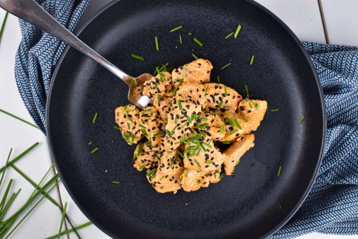 Bang Bang Chicken Bang Bang Chicken covered in a creamy sweet and spicy sauce with green onions and sesame seeds.