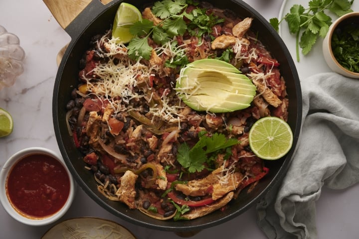 One Pot Mexican Chicken and Rice Mexican chicken and rice with chicken breast, peppers tomatoes, black bean, rice topped with avocado and cilantro.
