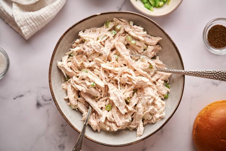 Healthy Chicken Salad Healthy chicken salad with shredded chicken, celery, greek yogurt, mayonnaise, and spices in a bowl.