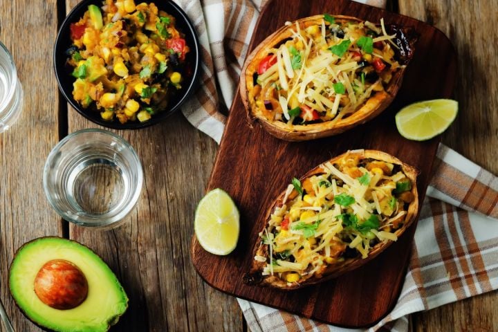 Southwest Stuffed Sweet Potato Stuffed sweet potatoes with Southwest ingredients including black beans, corn, diced tomatoes, green peppers, and cheese.