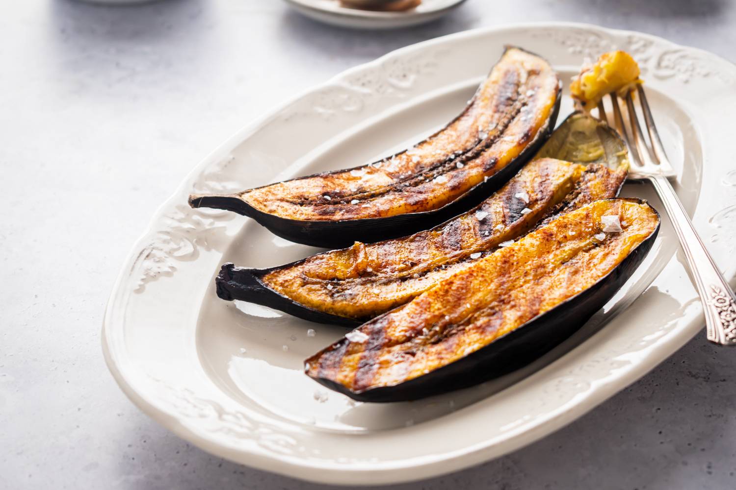 Grilled plantains with grill marks sprinkled with sea salt.