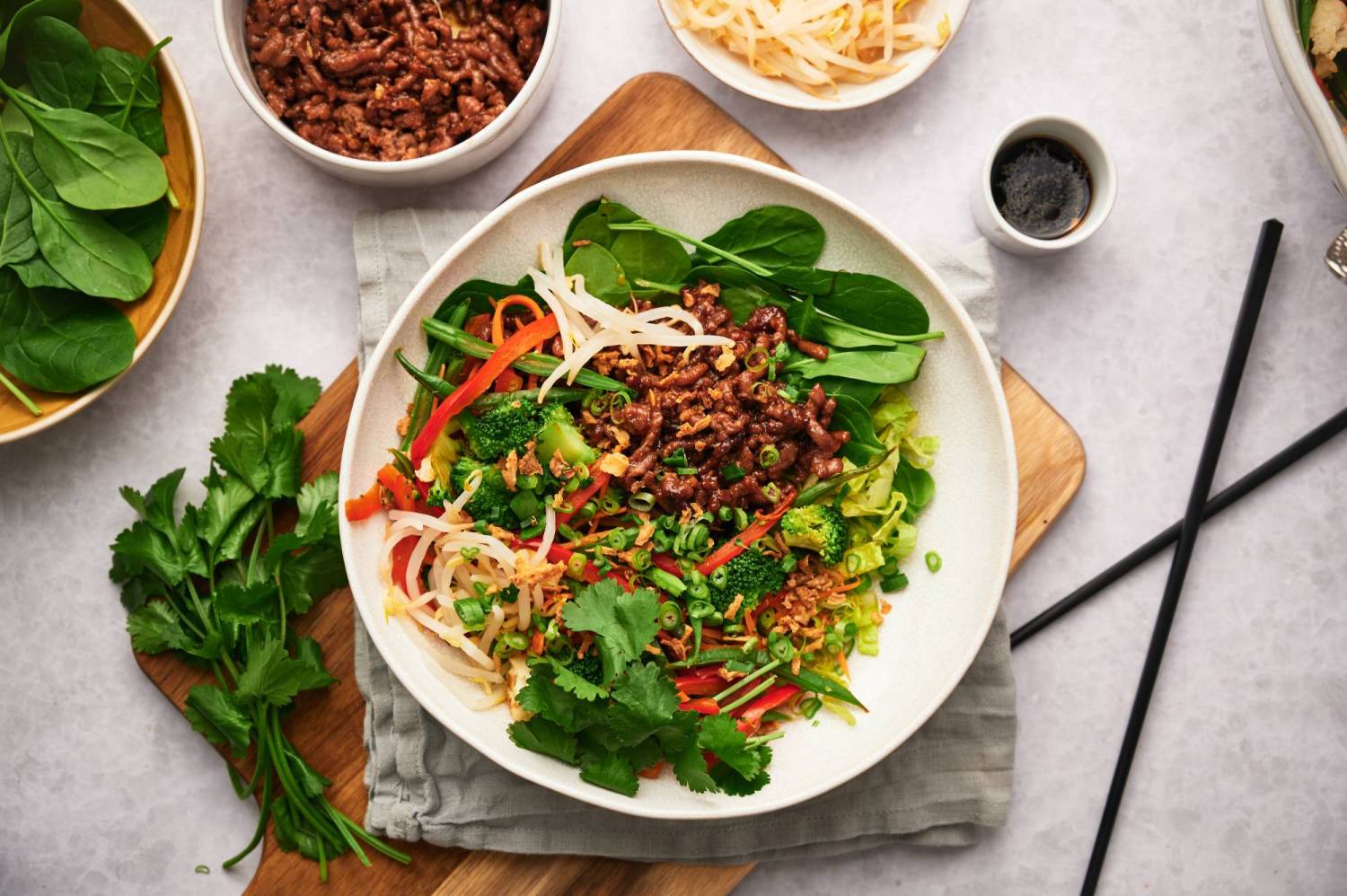 Ground beef bowls with spinach, broccoli, red bell peppers, and Korean ground beef in a bowl.