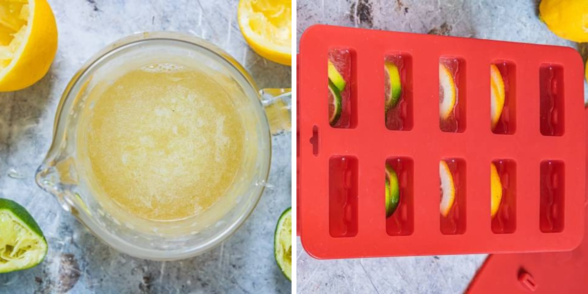 A glass pitcher filled with a light brown liquid sits beside halved lemons and a lime, alongside a red silicone ice tray with citrus slices.