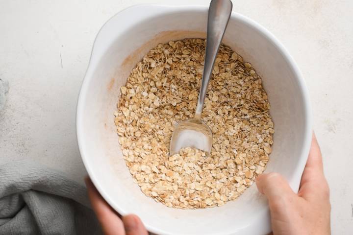 Oatmeal, baking powder, cinnamon, and flaxseed in a bowl.