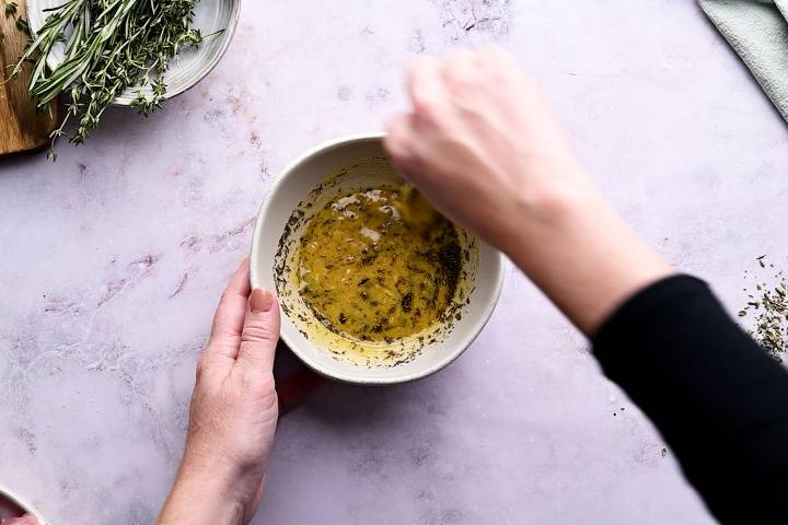 Thyme being stirred into maple mustard marinade for turkey.