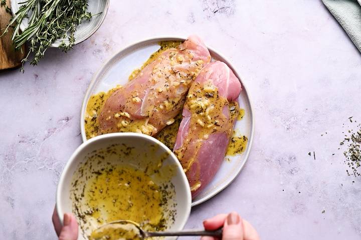 Turkey breast tenderloins being covered with marinade.