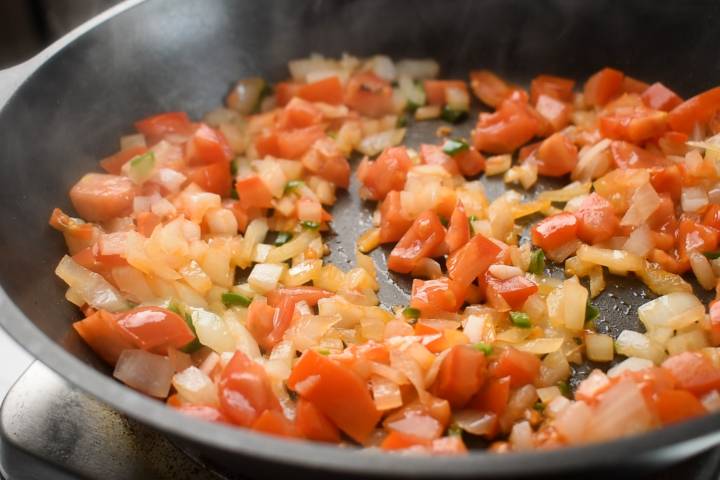 Tomatoes, onions, and jalapeno peppers in a skillet.