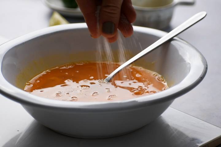 Whisked eggs with salt, pepper, and oregano in a bowl.