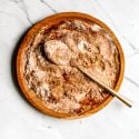 Fajita seasoning with chili powder, paprika, garlic powder, onion powder, and cumin mixed on a wooden plate.