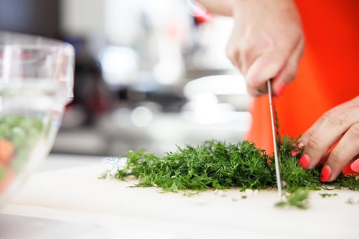 Liz cutting up dill for the yogurt dressing on orzo salad
