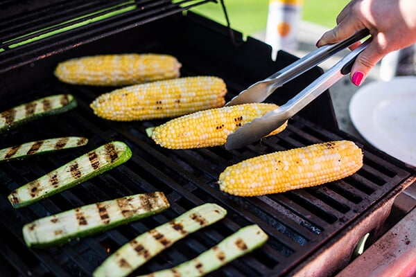 corn being grilled with zucchini