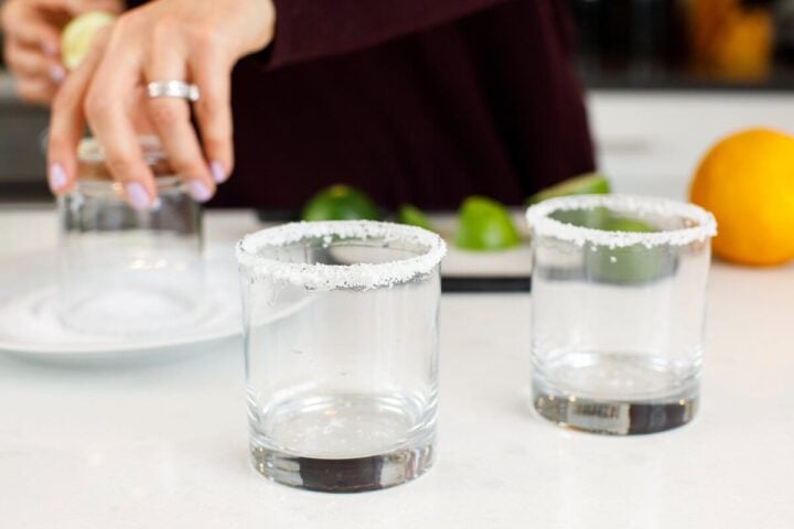 Glasses with salted rims set on the counter.