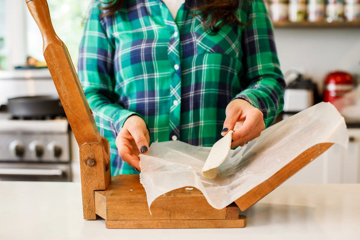 peeling corn tortilla from press