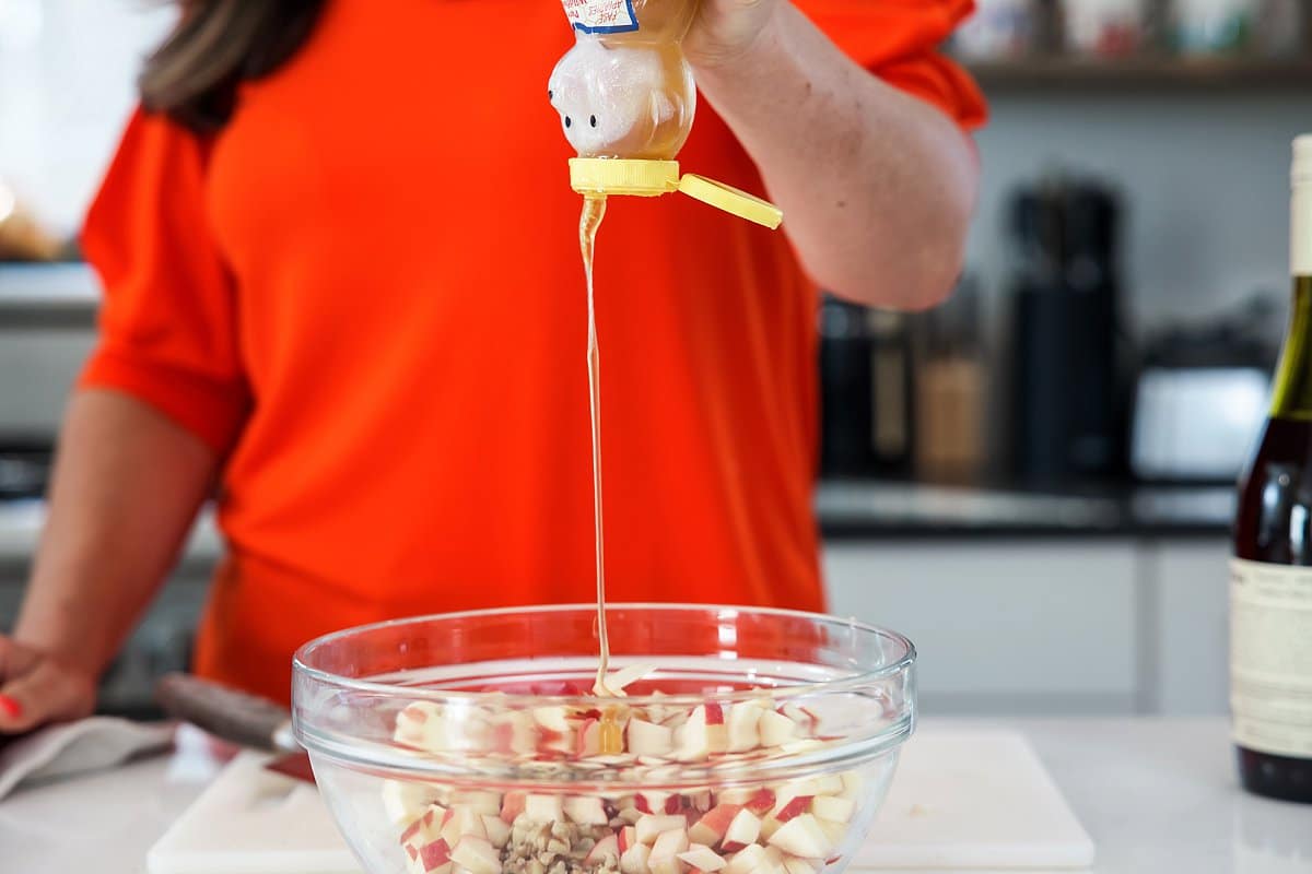 adding honey to charoset