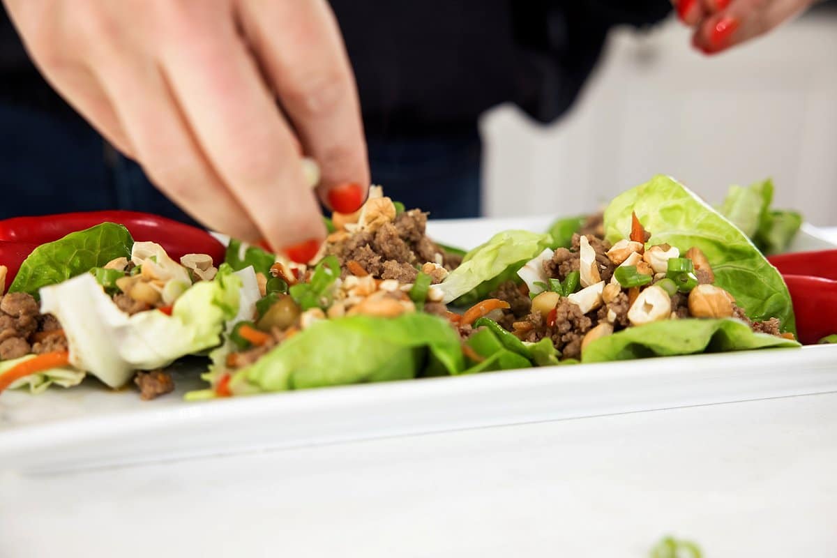 adding toppings to turkey lettuce cups