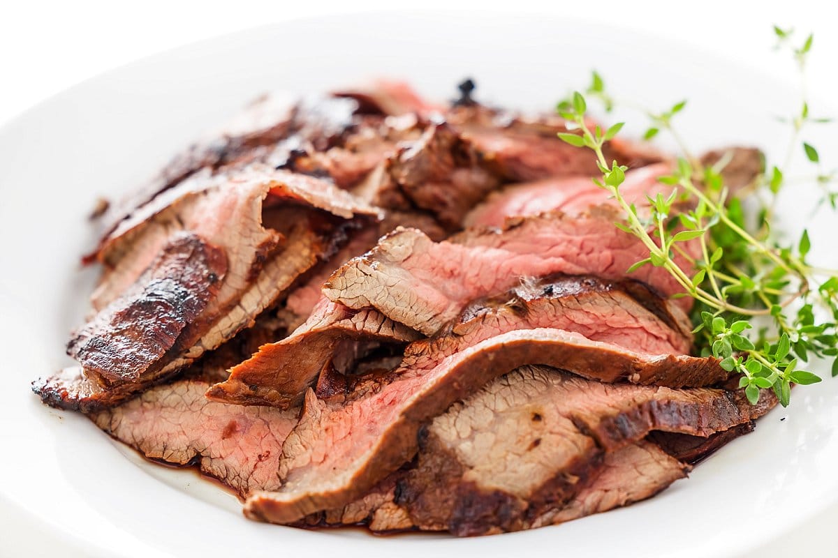 Closeup garlic soy marinated flank steak on a plate