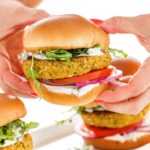person holding Vegetarian chickpea burgers with tzatziki sauce