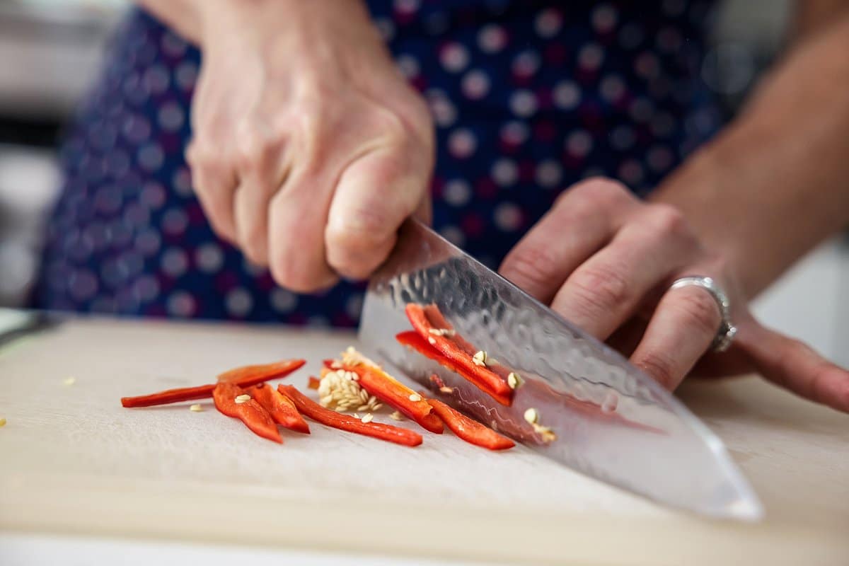 chopping red chili peppers