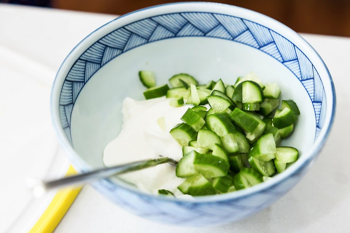 cucumbers and yogurt in a bowl for the salad wrap