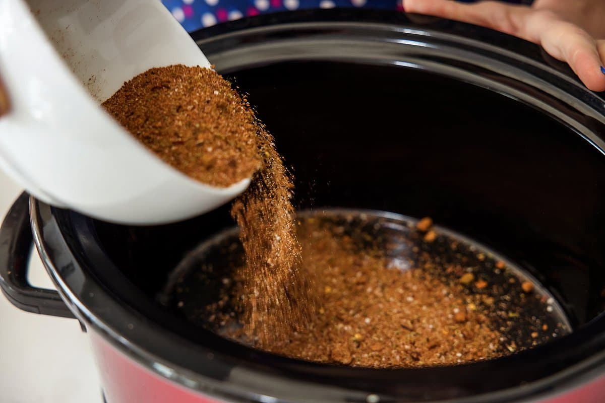 pouring seasoning into pot for beef
