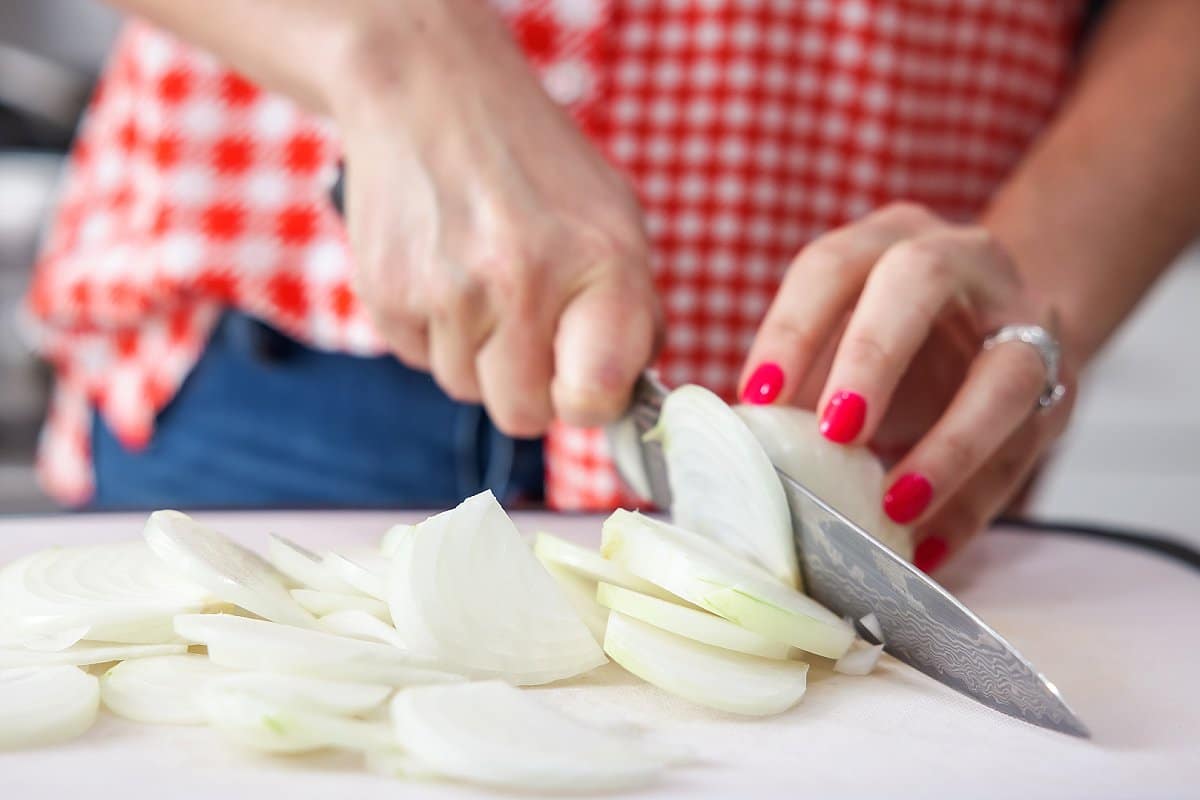 Liz slicing a white onion.