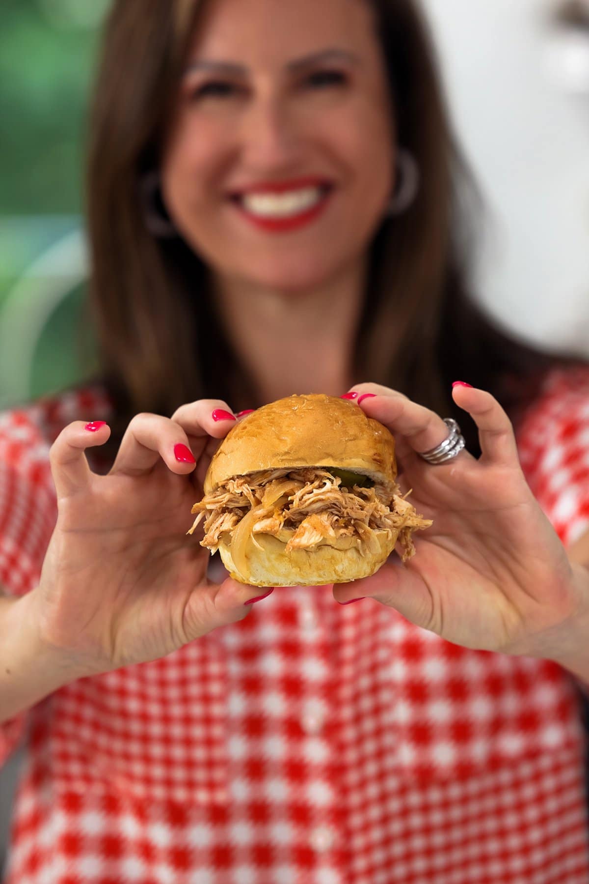 Liz holding up a BBQ pulled chicken sandwich.