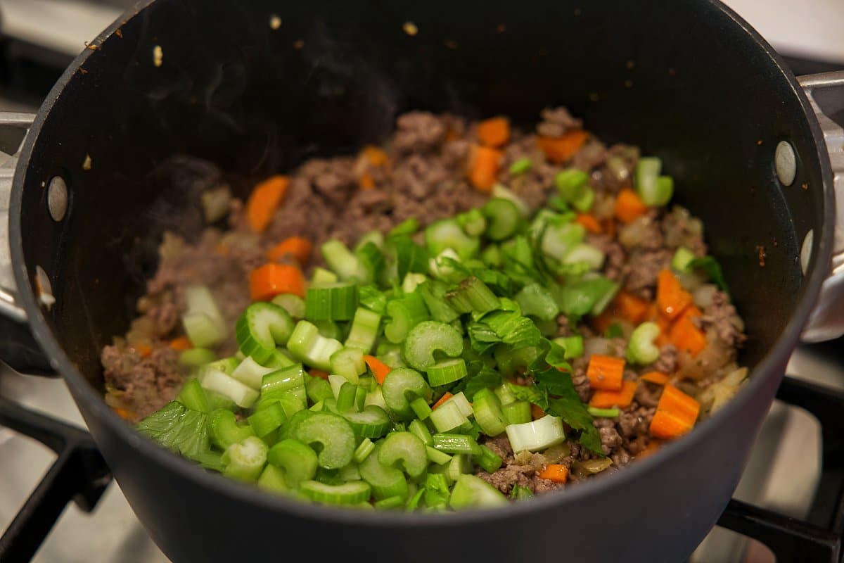 celery to soup in a pot