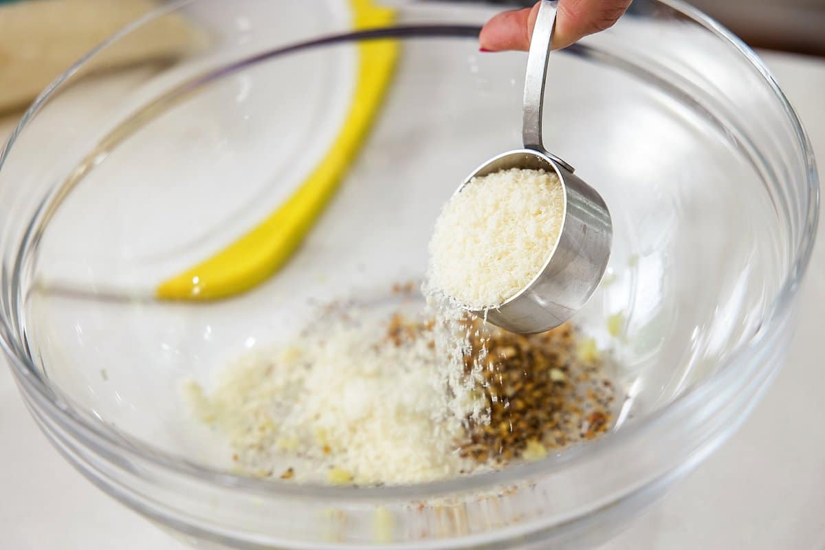 Adding parmesan cheese to bowl