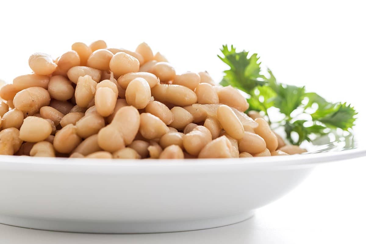 Cooked beans in a white bowl.