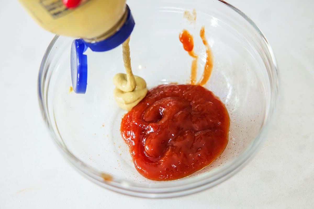Mixing ketchup and dijon mustard in a bowl