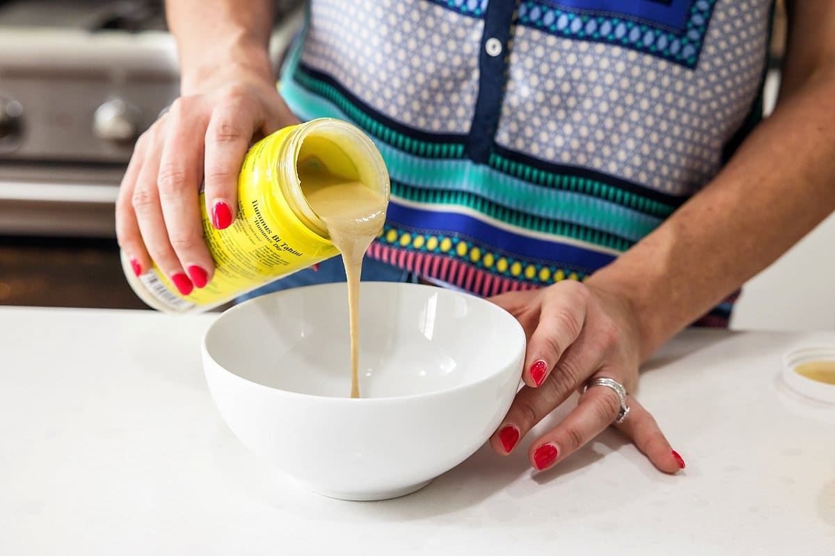 Pouring tahini in a bowl