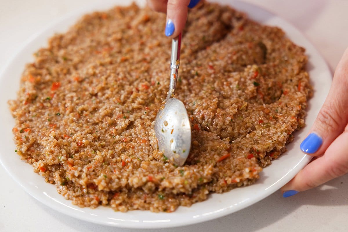 Tomato kibbeh being spread on plate