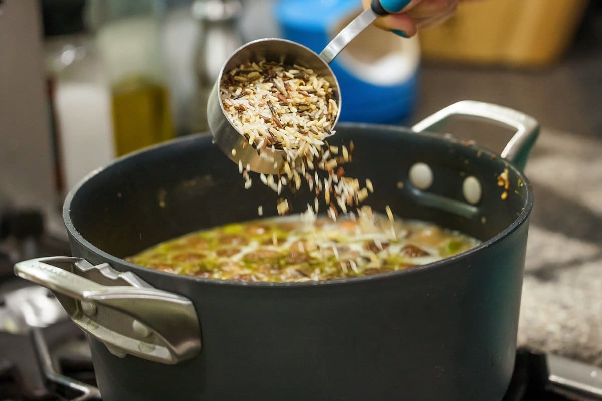 Adding wild rice to creamy vegan mushroom soup.