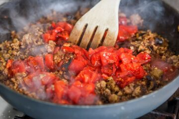 Diced tomatoes added to pan