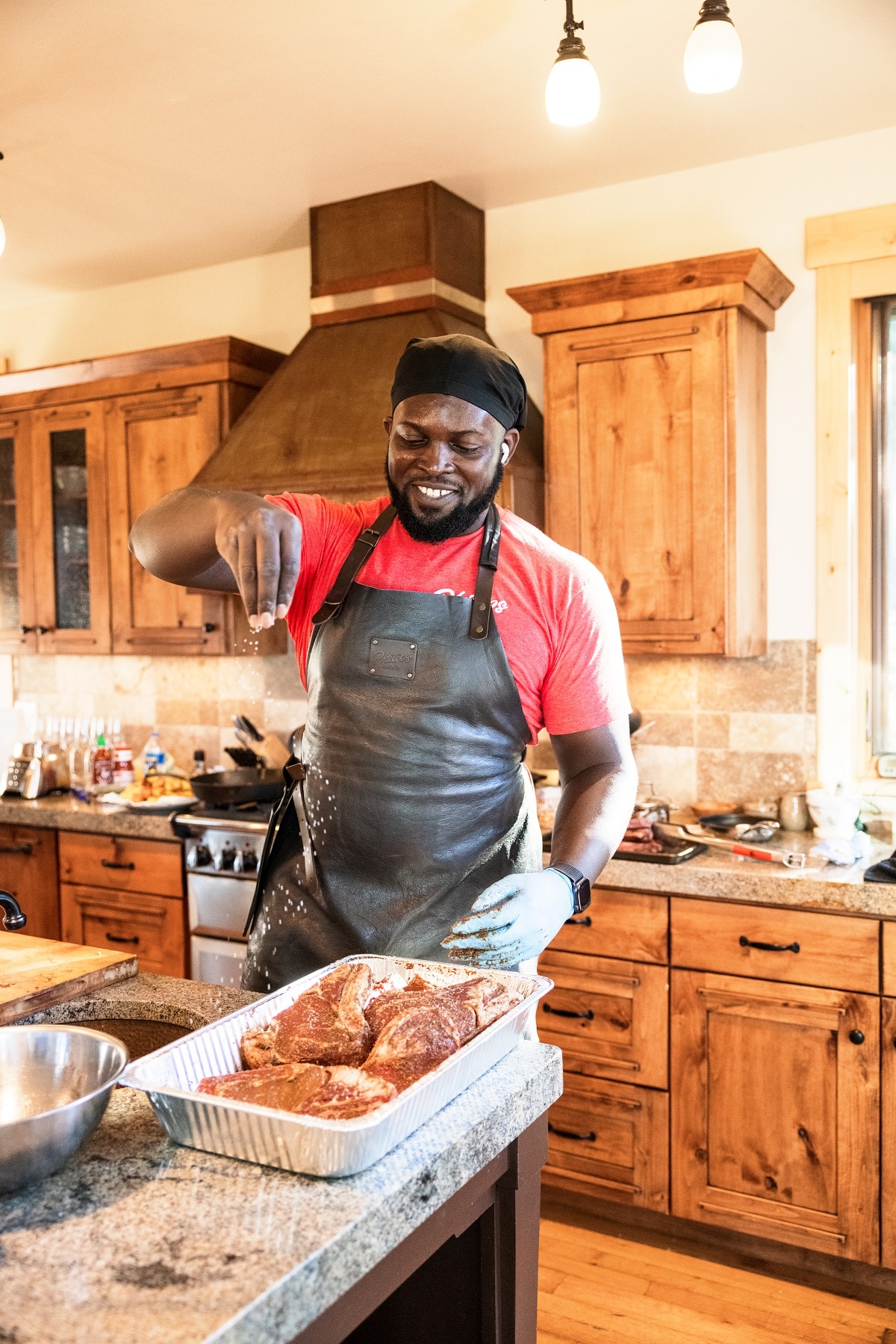 A person preparing food in a kitchen, with Beef and Steak