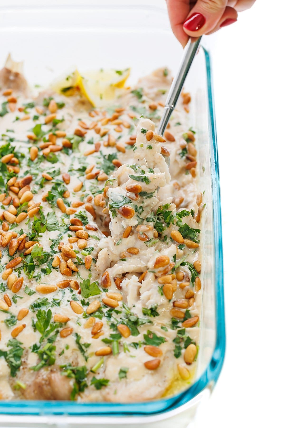 Lebanese baked fish with tahini sauce and roasted pine nuts.