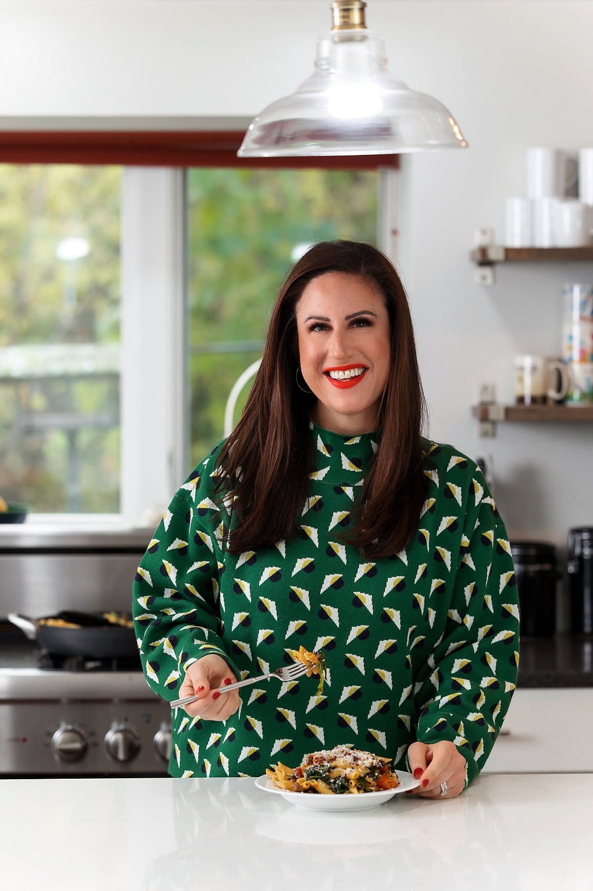 Liz eating fire roasted sausage and kale pasta.