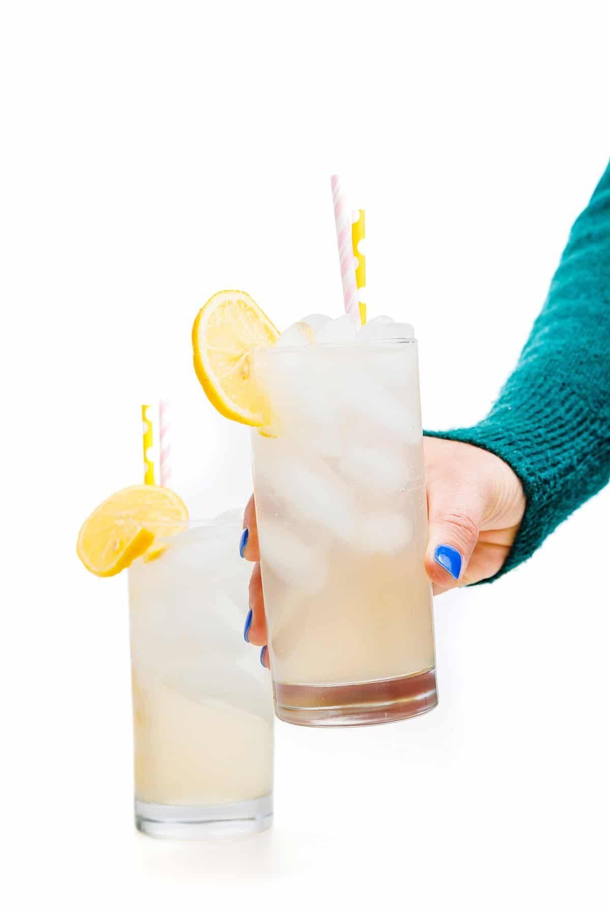 Holding glass of sparkling orange blossom water lemonade.