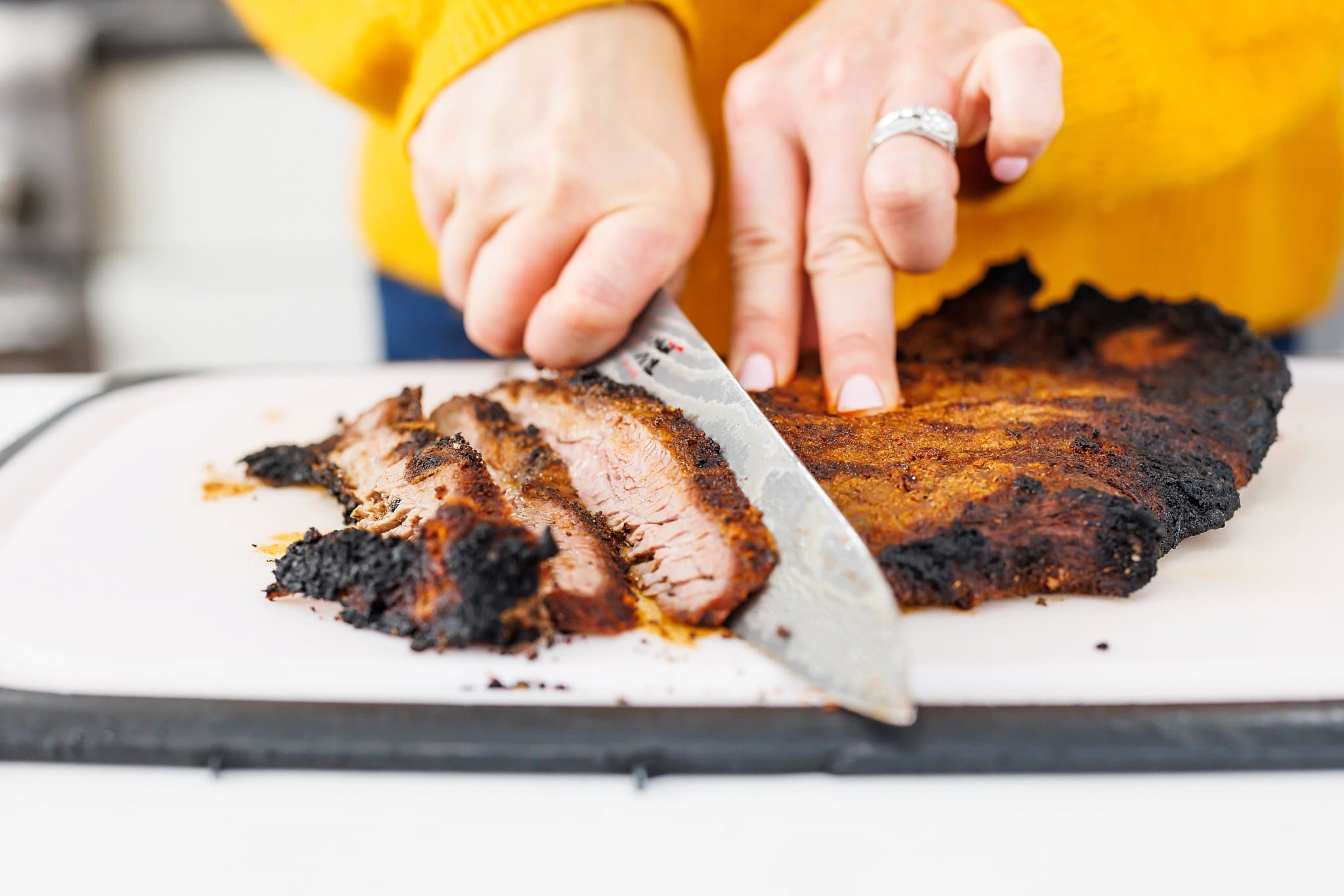 Liz slicing grilled flank steak into thin slices.