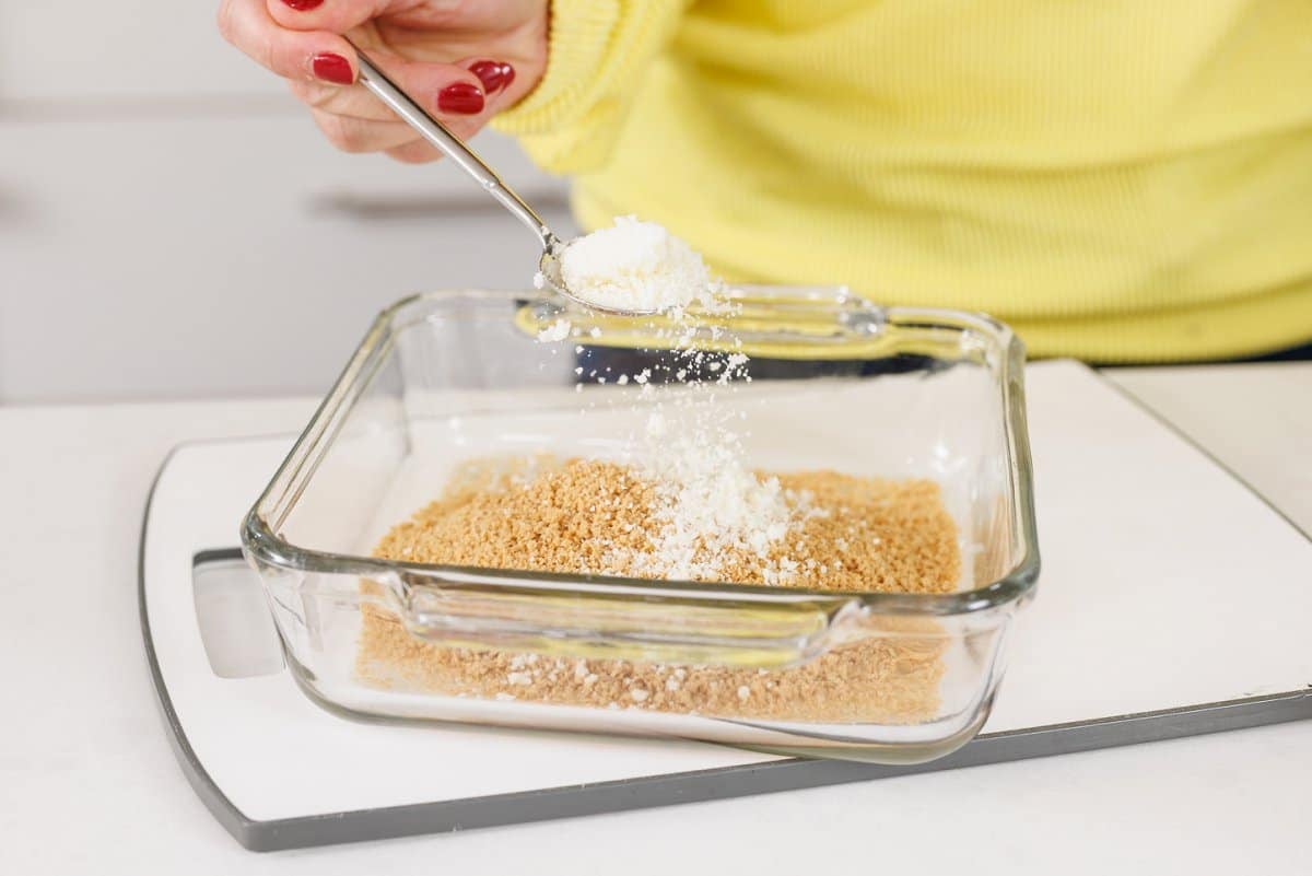 Adding parmesan cheese to pan of panko bread crumbs.