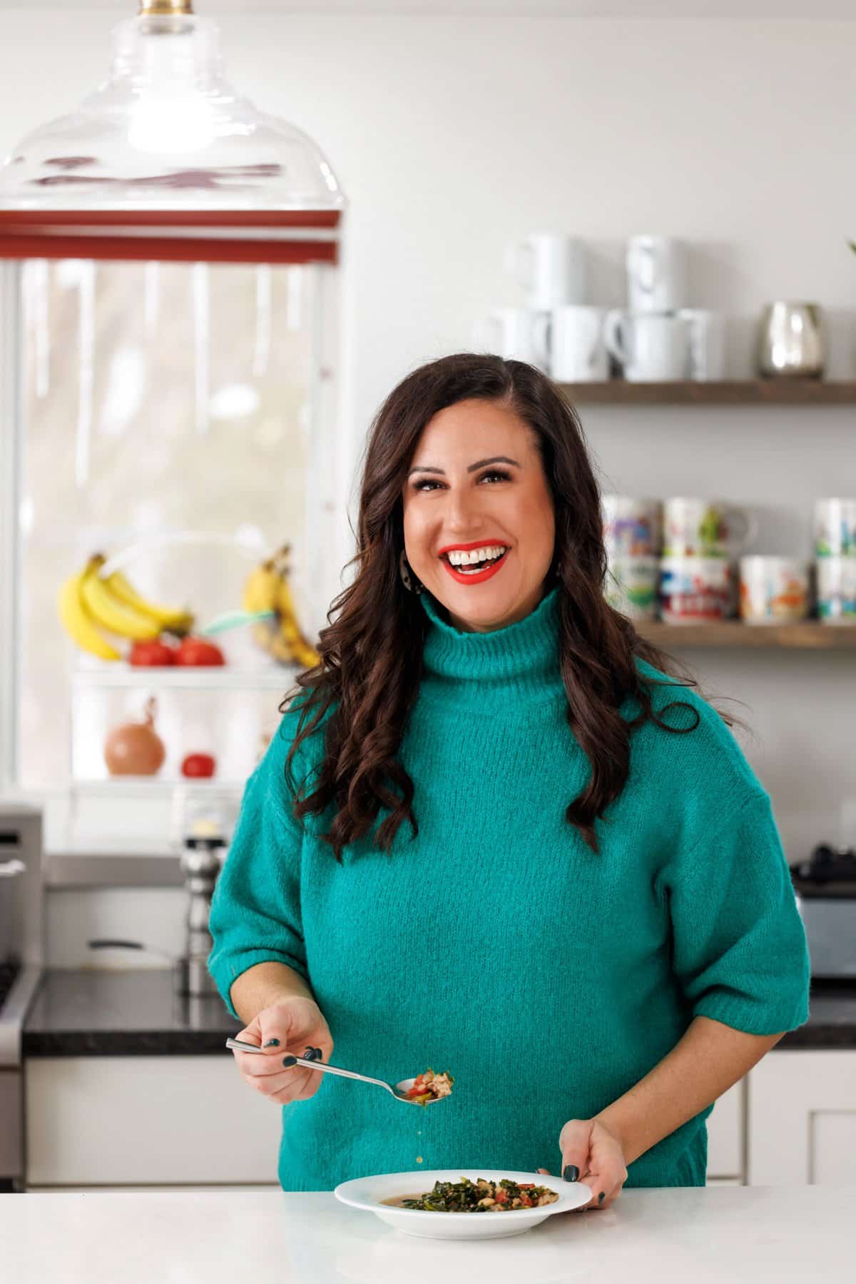 Liz eating a spoonful of sausage, kale, and white bean soup.