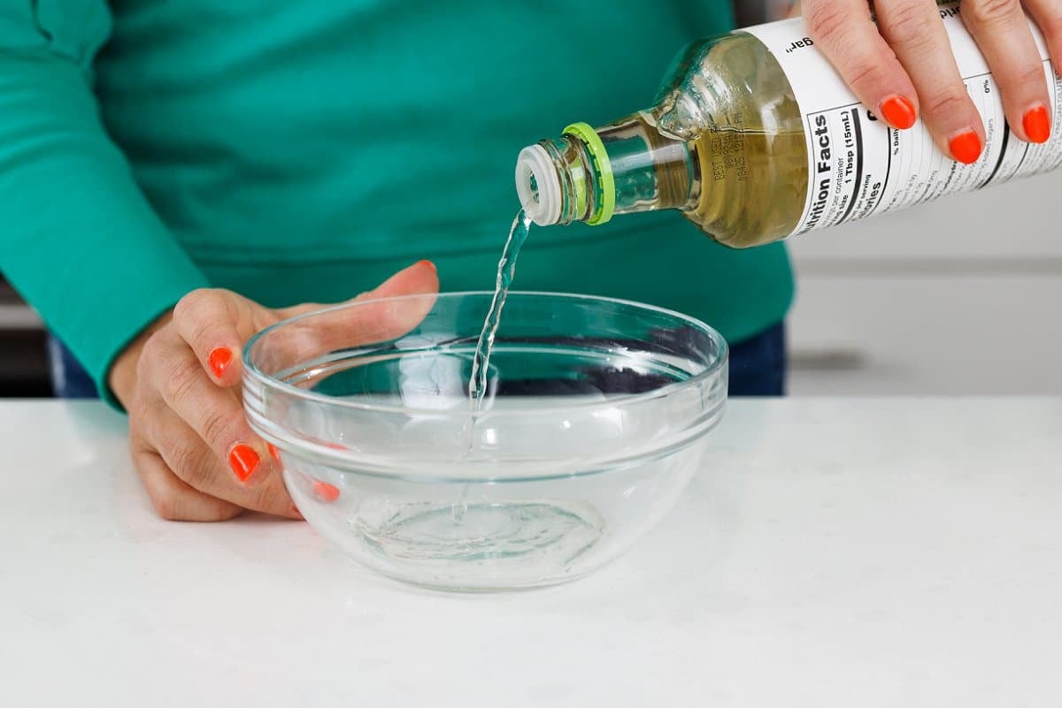 Adding rice wine vinegar to glass bowl.