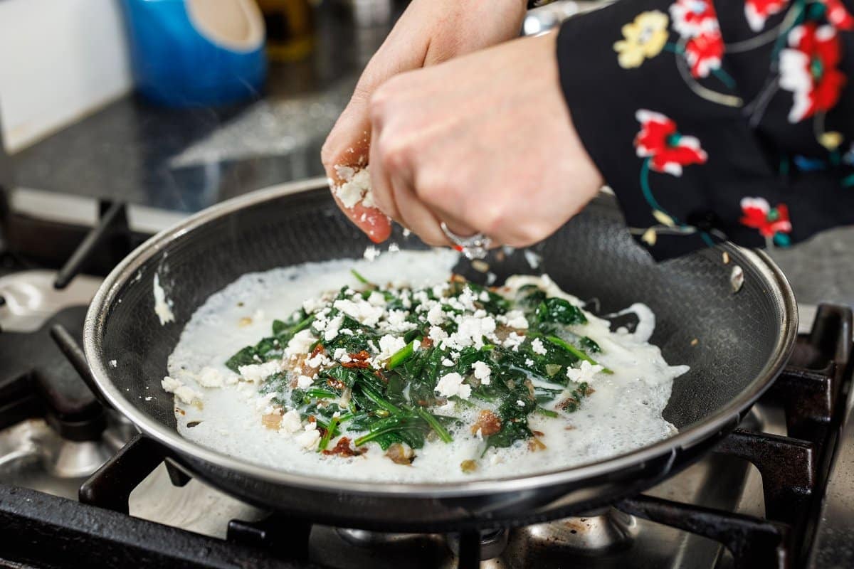 Crumbling feta cheese over omelette.
